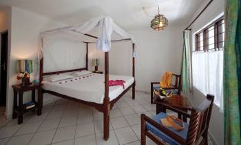 a bedroom with a bed and desk in a small room