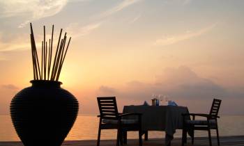 a chair sitting in front of a sunset