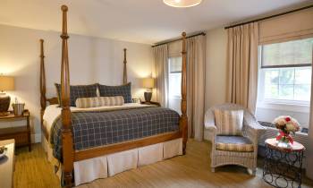 a bedroom with a bed and a chair in a room