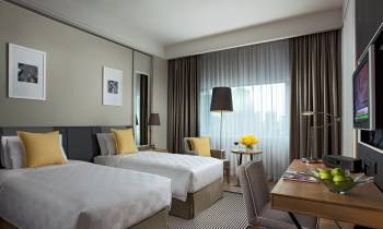a bedroom with a bed and desk in a hotel room