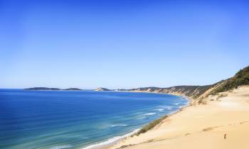 a sandy beach next to a body of water