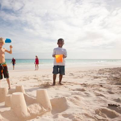 a group of people standing on top of a sandy beach