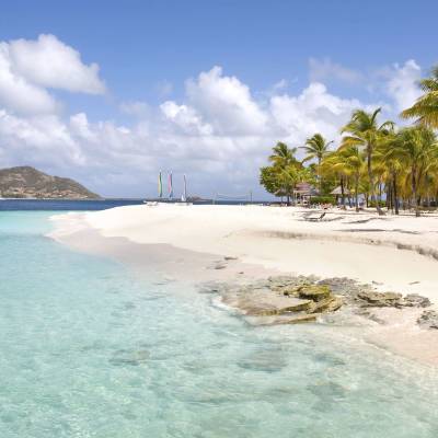 a sandy beach next to a body of water