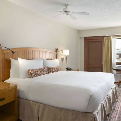 a bedroom with a bed and desk in a hotel room