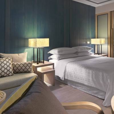 a bedroom with a bed and a chair in a room