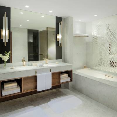 a white sink sitting under a large mirror