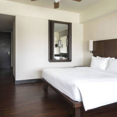 a bedroom with a bed and a mirror in a room
