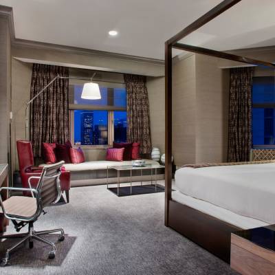 a bedroom with a bed and desk in a room