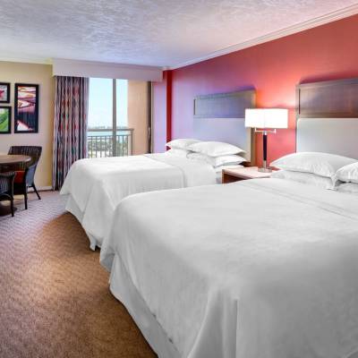 a bedroom with a bed and desk in a hotel room