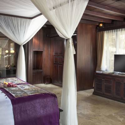 a bedroom with a bed and a chair in a room