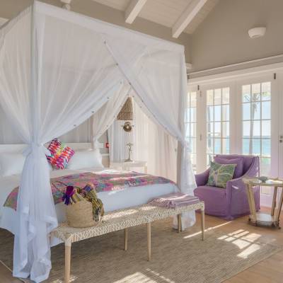 a bedroom with a bed and a chair in a room