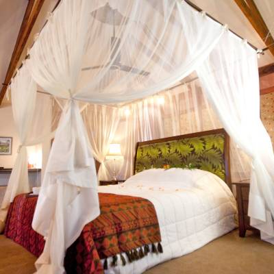 a bedroom with a bed and a chair in a room