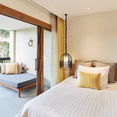 a bedroom with a bed and a chair in a room