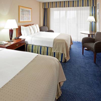a bedroom with a bed and desk in a hotel room