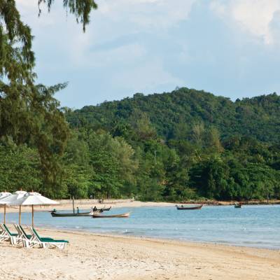 a group of lawn chairs sitting on top of a sandy beach