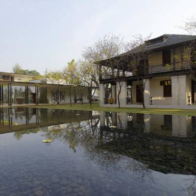 a bridge over a body of water in front of a house