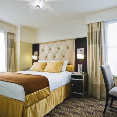 a bedroom with a bed and desk in a hotel room