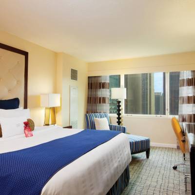 a bedroom with a bed and a chair in a room