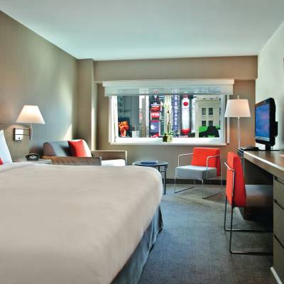 a bedroom with a bed and desk in a hotel room