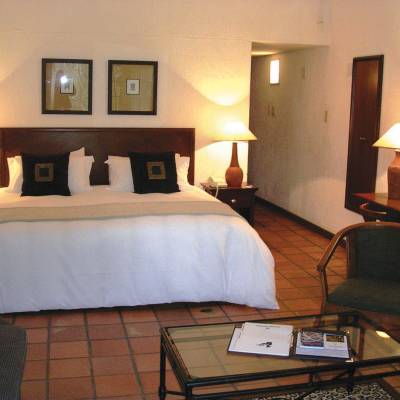 a bedroom with a bed and desk in a hotel room