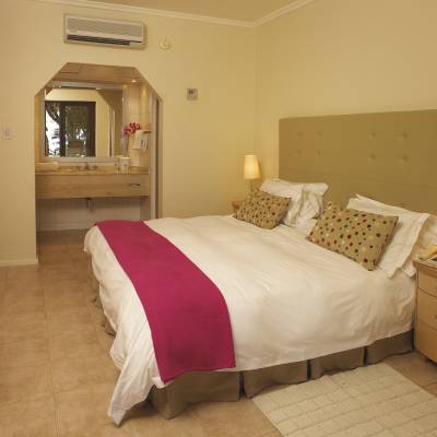 a bedroom with a bed and desk in a hotel room