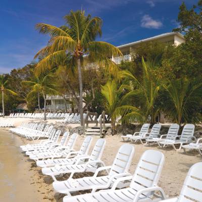 a group of lawn chairs sitting on top of a sandy beach