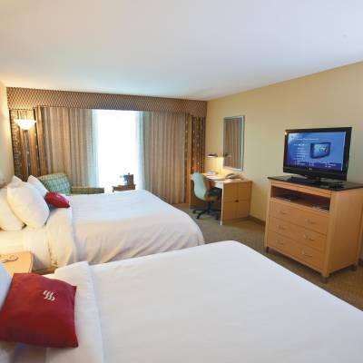 a hotel room with a flat screen tv sitting on top of a bed