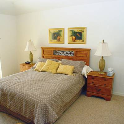a bedroom with a bed and desk in a room