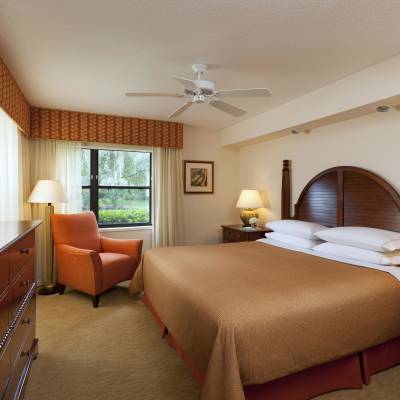 a bedroom with a bed and desk in a hotel room