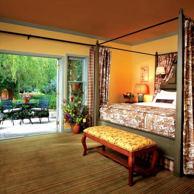 a living room filled with furniture and a bed in a bedroom