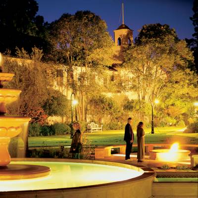 a fountain in front of a building lit up at night