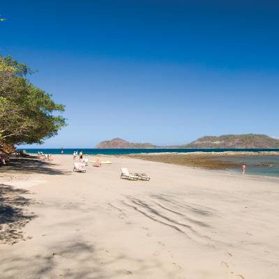 a sandy beach next to a body of water