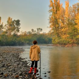 Wanderin mit Gummistiefeln steht am Tumut-Fluss in New South Wales, Australien