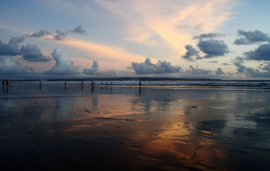 Menschen bei Dämmerung am Seminyak-Sandstand auf Bali, Indonesien