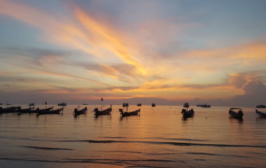 Kanus am Strand von Thailand beim Sonnenuntergang