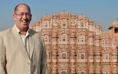 Lachender Tourist vor dem Hawa Mahal (Palast der Winde) in Jaipur, Indien