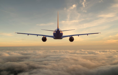 Commercial-passenger-plane-flies-above-the-clouds-towards-the-setting-sun