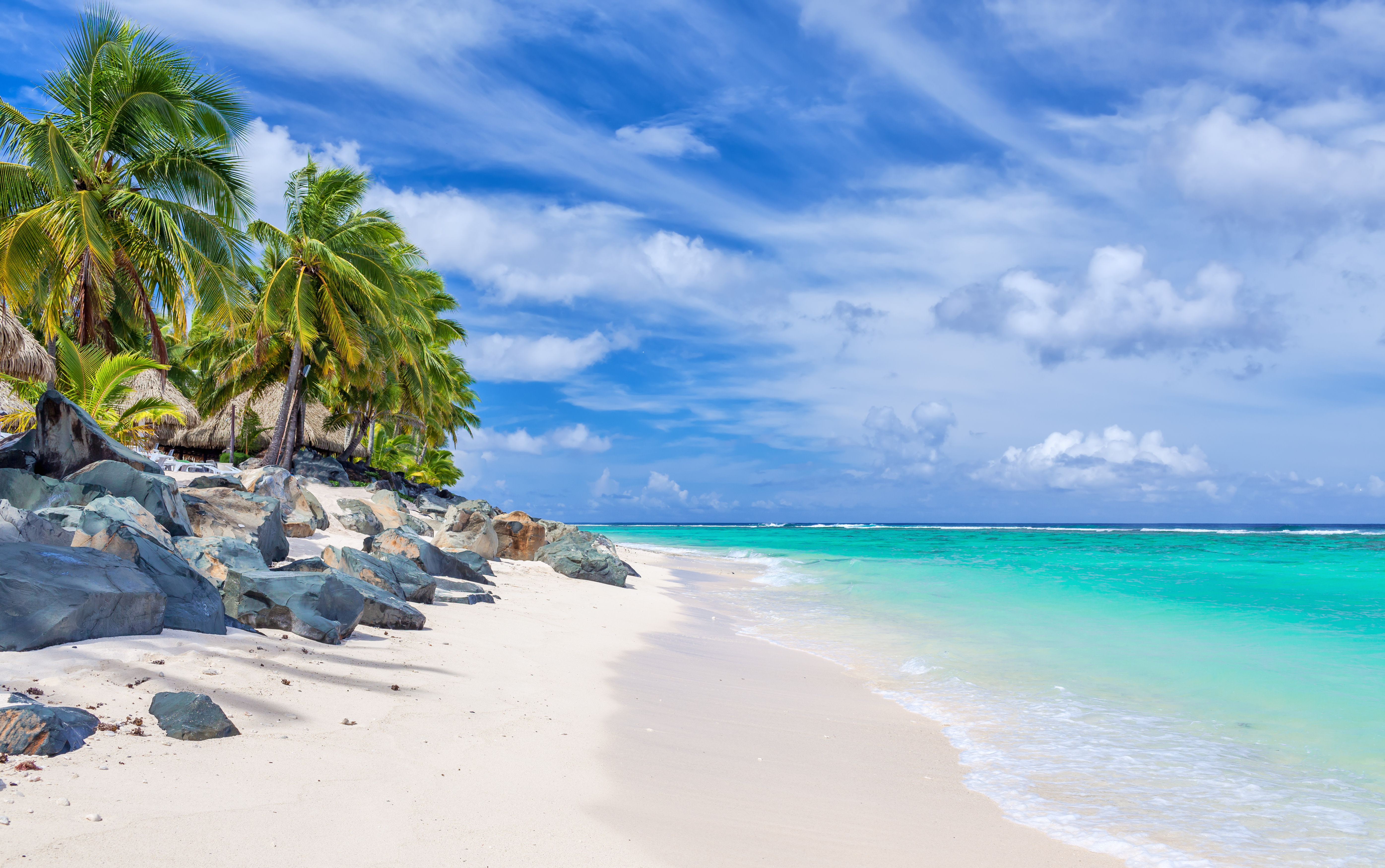 Stunning white sandy tropical beach with rocks and palms on Rarotonga, Cook Islands Best time to visit Cook Islands