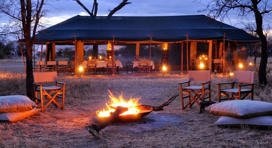 Zelt mit Tischen und Lagerfeuer in einem der Safari Camps