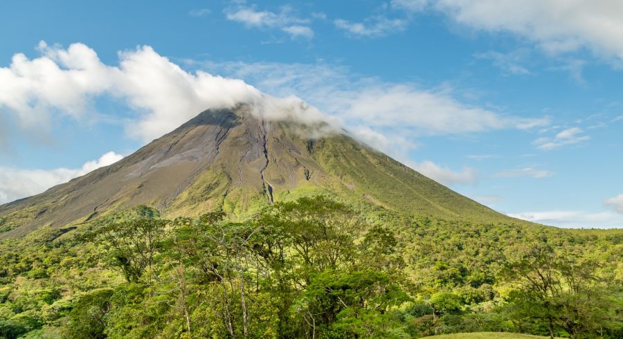 The Arenal volcano surrounded by clouds. This is an active volcano in tropical Costa Rica. The volcano slopes are covered in primary forest full of wildlife.