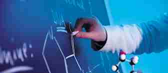 A person in a lab coat is drawing a molecular structure on a chalkboard with chalk. The other hand is holding a molecular model. The chalkboard has various scientific notations and diagrams related to DNA under a blue light.
