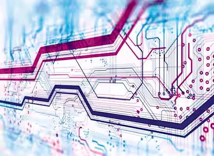 Close-up image of a complex, multi-layered circuit board with intricate, overlapping lines in shades of blue, red, and purple, representing electronic pathways and connections. The design appears dense and detailed, showcasing modern technology intricacies.