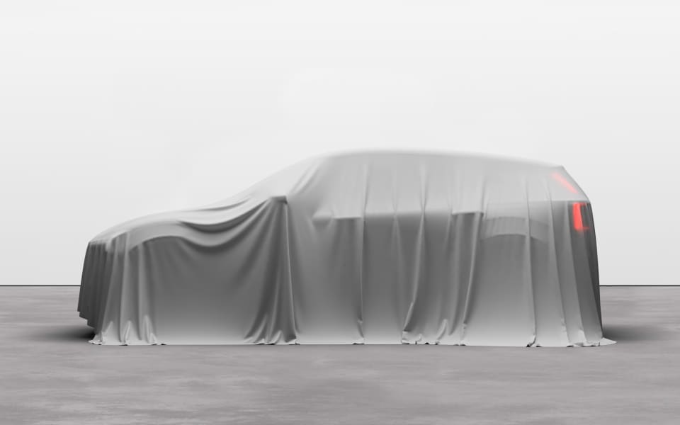 En Volvo EX30 parkert i et studio, kunstferdig drapert i et tynt hvitt slør som skjuler de utvendige detaljene.