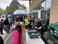 vegetables being handed out to a queue of people vegetables being handed out to a queue of people