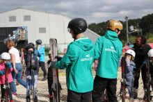Two ski instructors watching over a group of women and girls learning to ski