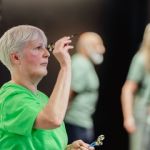 Shows a woman playing darts
