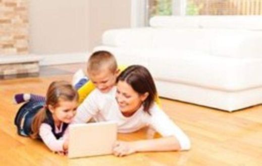 Carer and two children looking at a tablet Carer and two children looking at a tablet