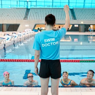instructor demonstrating technique in front of learners in the pool