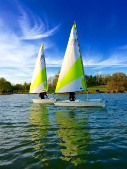 Two sailing dinghies on Stanborough Lake White & Green Sails