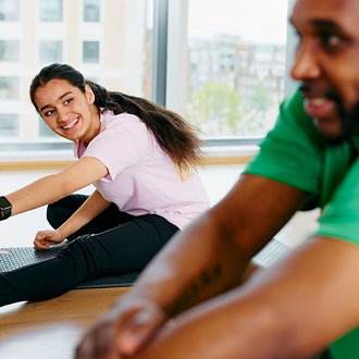 A teenage girl stretching in an exercise class A teenage girl stretching in an exercise class